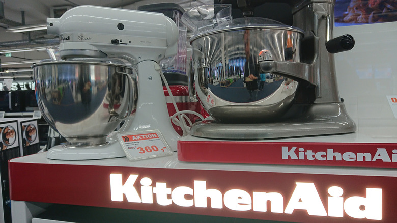 KitchenAid stand mixers on display in a showroom with the KitchenAid logo illuminated below them