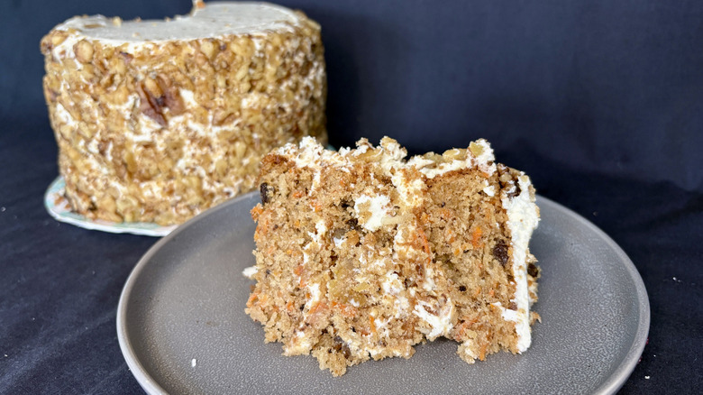 slice of carrot cake from Magnolia Bakery on gray plate with full cake in background