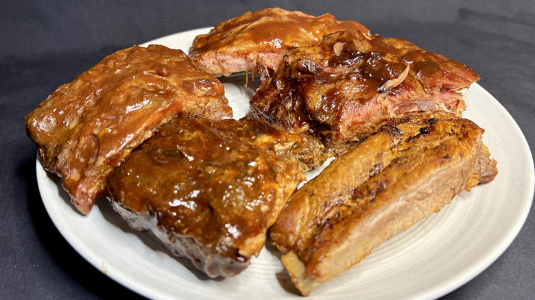 Multiple barbecue ribs on a white plate