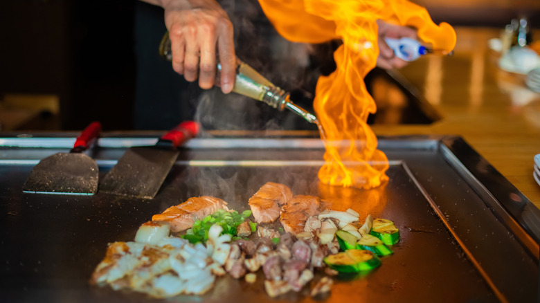 Meat and veggies cooking on a teppanyaki grill