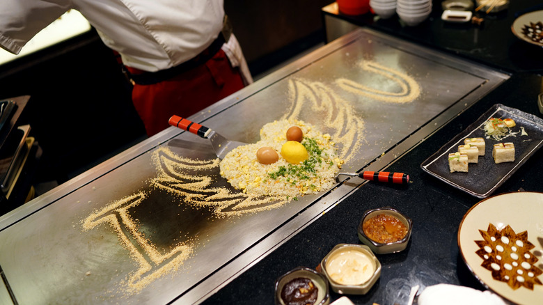 Fried rice with eggs on top displayed as a heart face on a teppanyaki cooktop