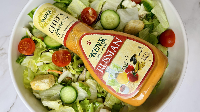 A bottle of Ken's Steak House Chef's Reserve Russian Dressing sitting in a bowl of salad