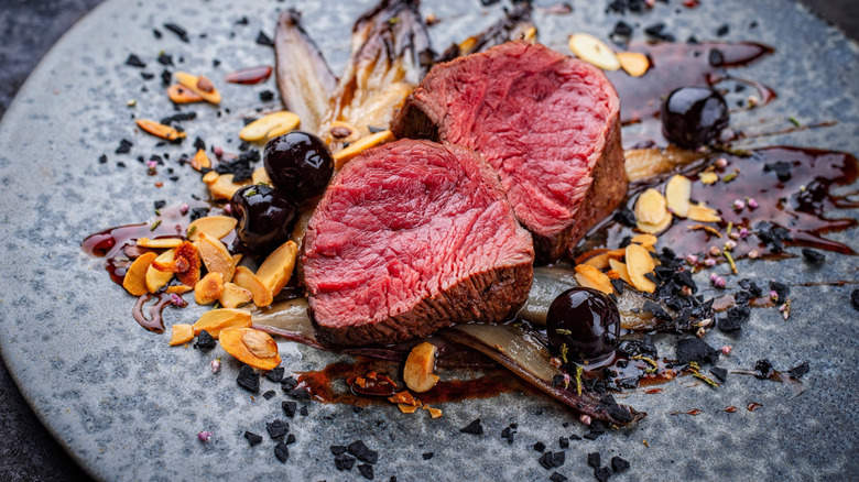 A filet mignon dish with berries.