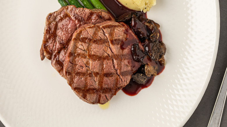 Plate of steak with asparagus, mashed potatoes, and steak sauce