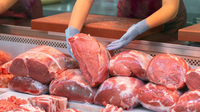 Hands removing piece of beef from case