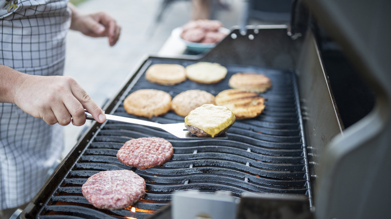 Large grill with burger patties and buns
