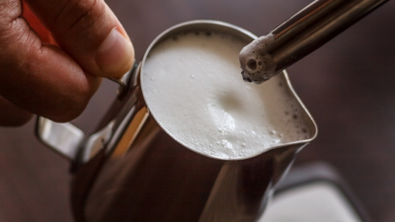 Steaming milk in metal carafe