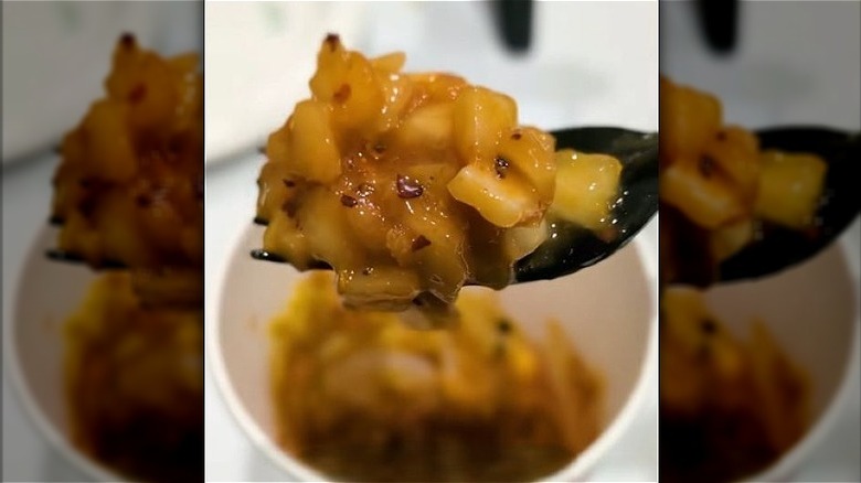 Forkful of Costco-made kimchi with onions, ketchup, mustard, and red pepper.