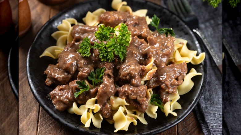 Ground beef with brown gravy over egg noodles