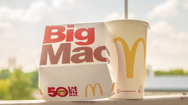 Closeup of a  Big Mac box next to a McDonald's drink cup