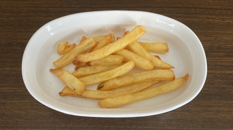 Golden and crispy french fries in a white dish