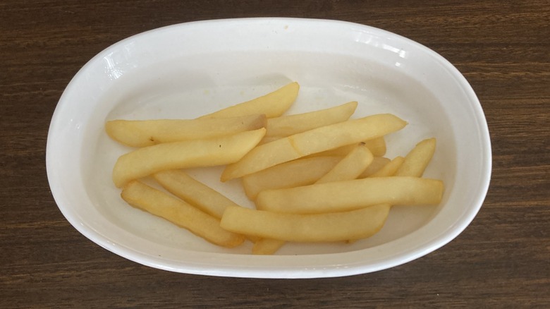 Pale and soggy french fries in a white dish