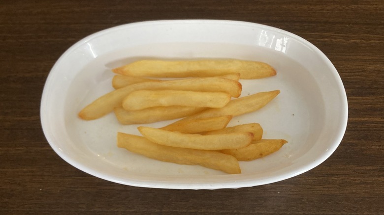 Pale cooked fries in a white dish