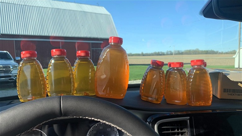 Honey jars lined up on a car dashboard