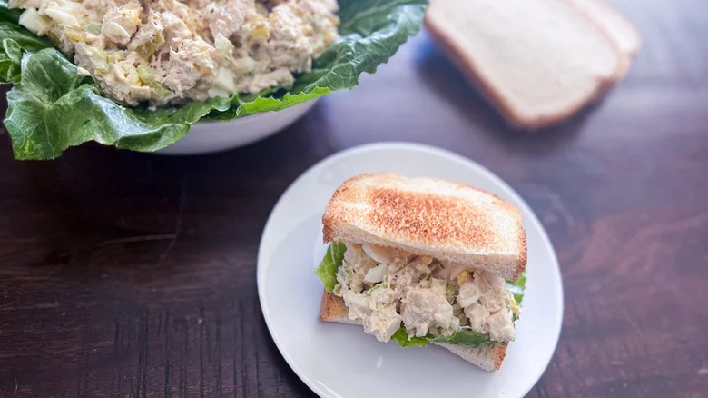 bowl of southern chicken salad with sandwich on side