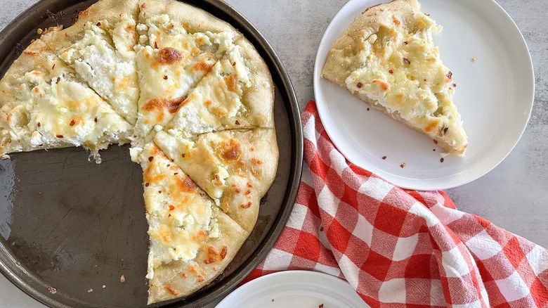New York-Style White Pizza with slice and checkered dish towel