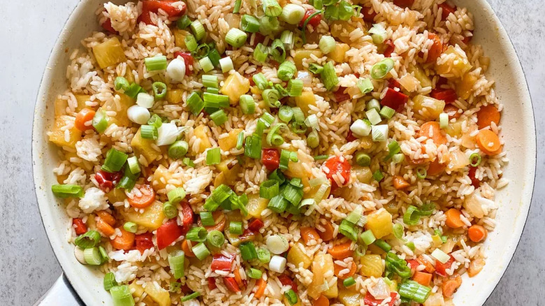 Skillet with rice, pineapple, and scallion mixture.