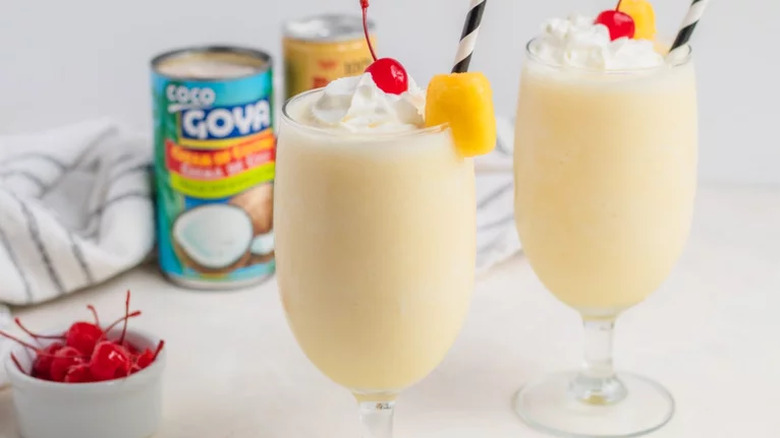 Creamy cocktails in tall glasses with cherries.