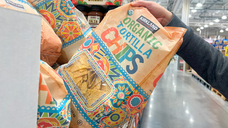 hand grabbing a bag of Organic Tortilla Chips at Costco