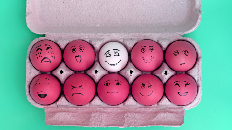 eggs in a carton with painted faces
