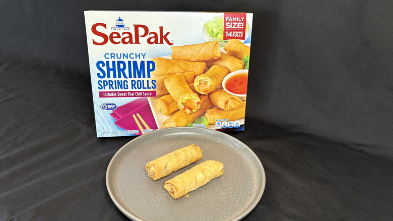 Two spring rolls on plate in front of SeaPak box