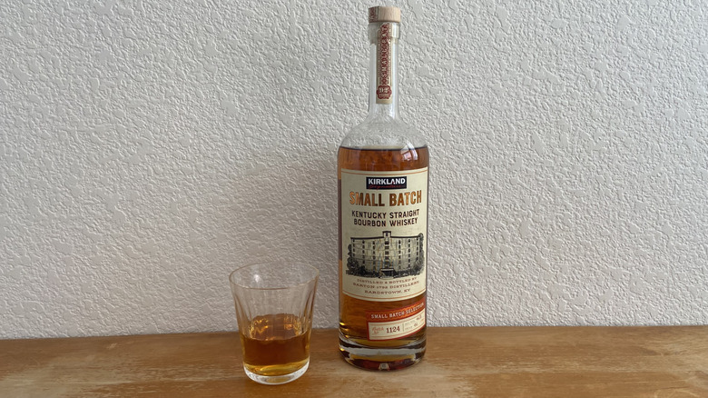 Kirkland Signature Small Batch bourbon beside half-full glass
