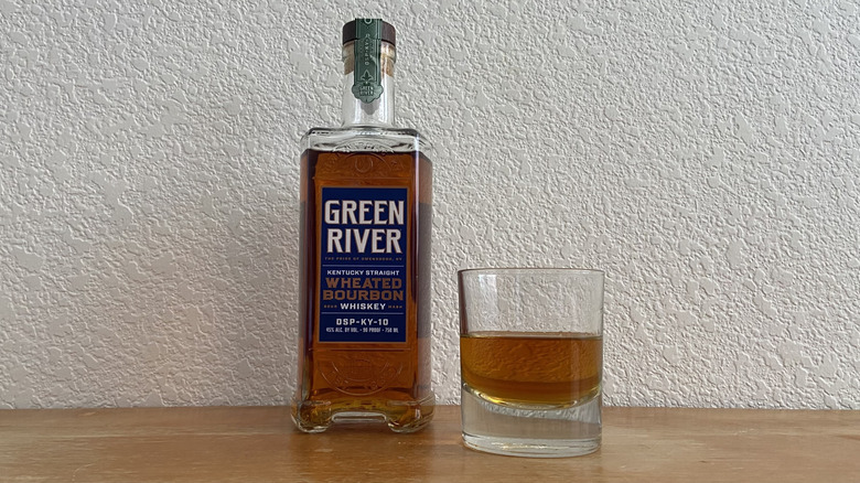 Green River Wheated Bourbon bottle beside half-full glass