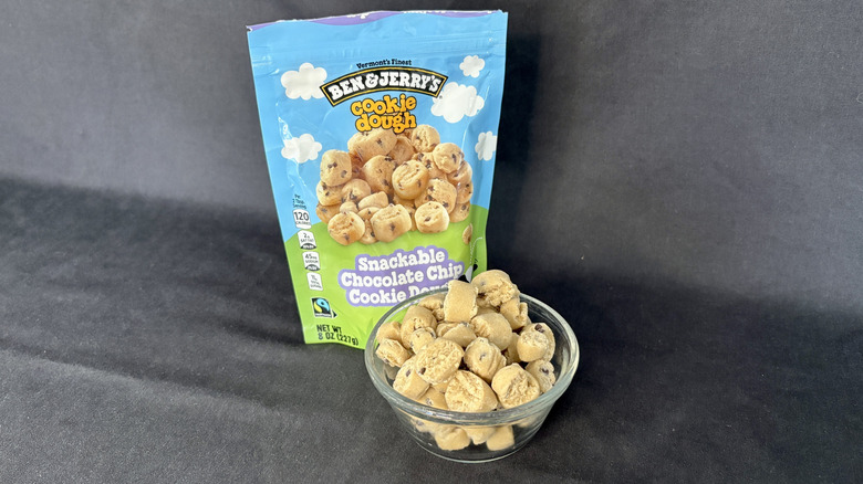 A glass bowl of Ben & Jerry's Snackable Chocolate Chip Cookie Dough bites with the packaging behind