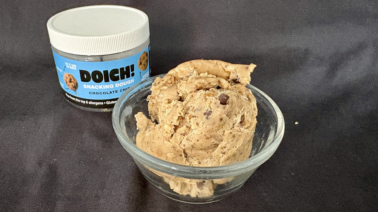 A scoop of Doich Snacking Dough in a glass bowl with the package behind