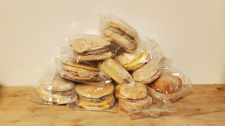 a pile of frozen breakfast sandwiches in their transparent plastic packaging