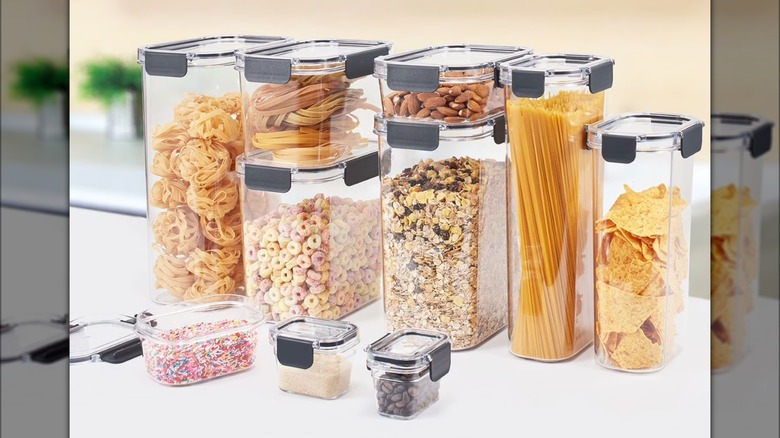 Several clear containers filled with nuts, cereals, pasta, and other foods.