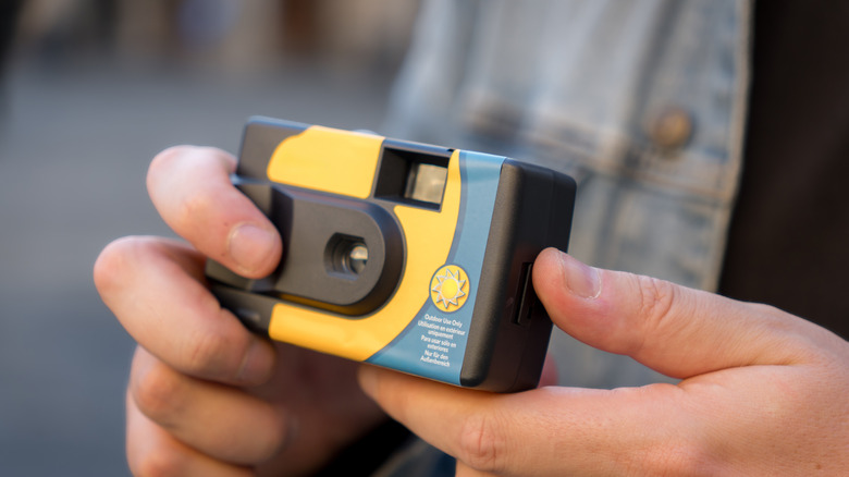 Hands holding a disposable camera