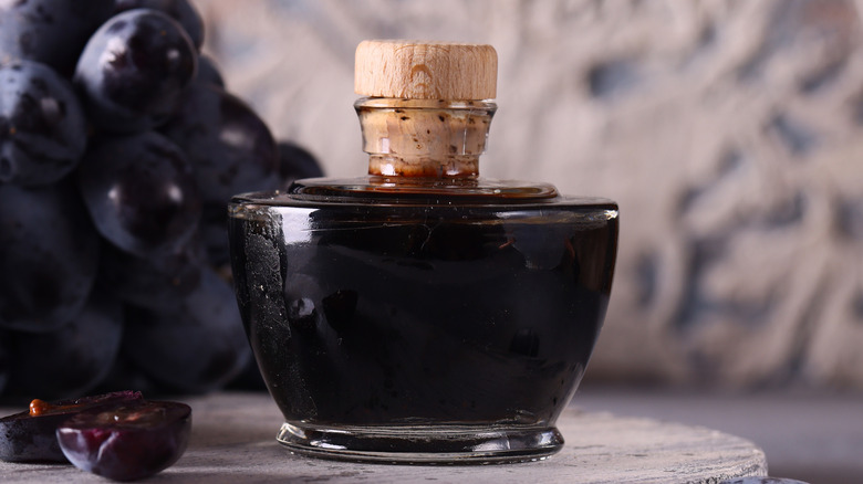 Artisan bottle of balsamic vinegar next to grapes