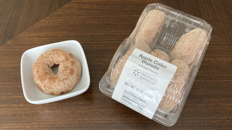 Freshness Guaranteed apple cider donuts in a package next to one on a mini plate