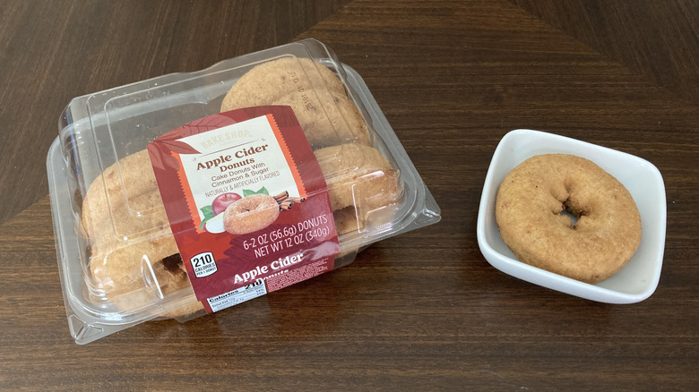 Bake Shop apple cider donuts in a package next to one on a mini plate