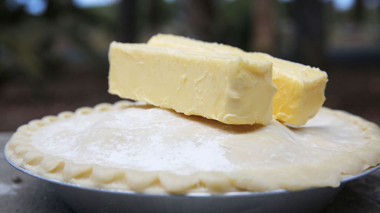 Two sticks of margarine on top of an unbaked pie