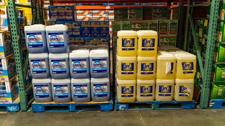 Bulk-sized containers of Dawn and Joy dish soap sit on pallets