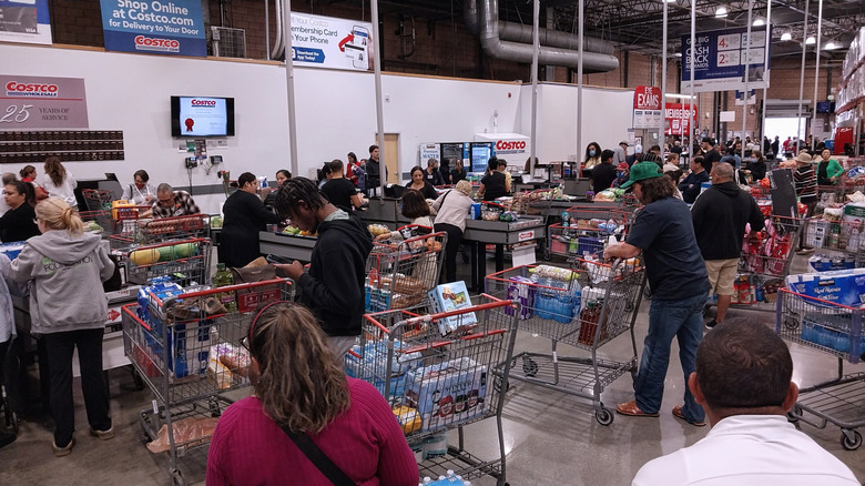 Customers line up with their shopping carts at Costco checkout lines