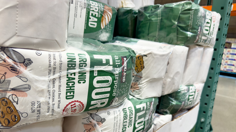Packages of Kirkland Signature organic all-purpose flour stacked at the end of an aisle in Costco