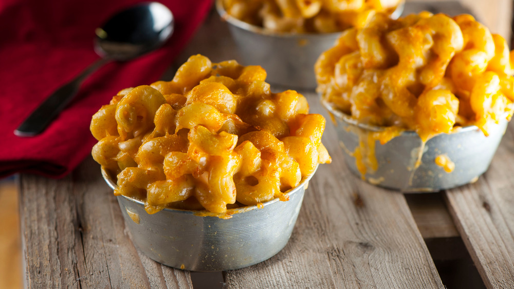 mac and cheese in small metal bowls on wood surface