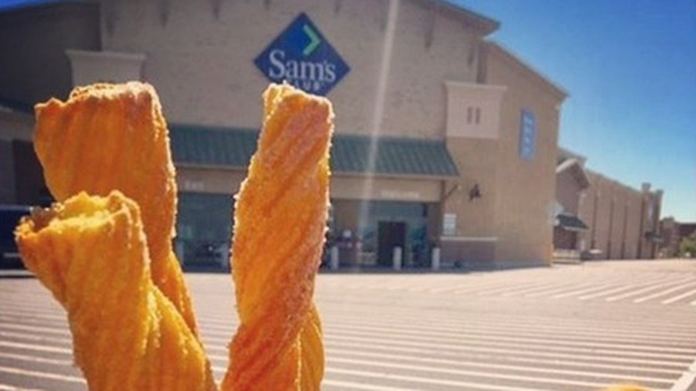 Sam's Club's food court churros being held up in front of the Sam's Club building