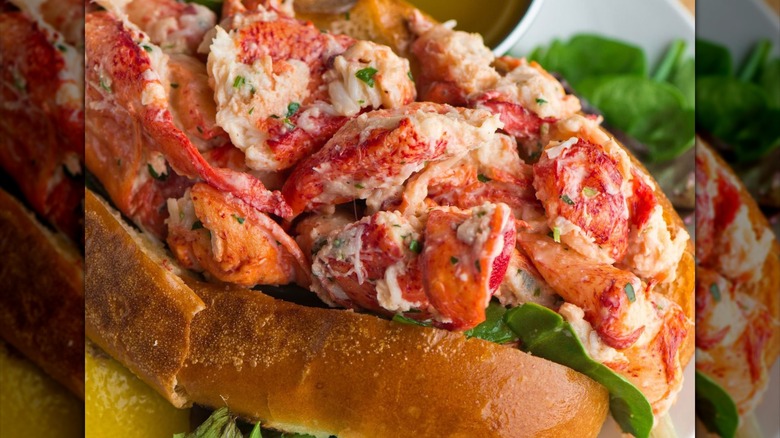 Sam's Club Member's Mark lobster roll salad on a bun and a white plate that is atop a wood table