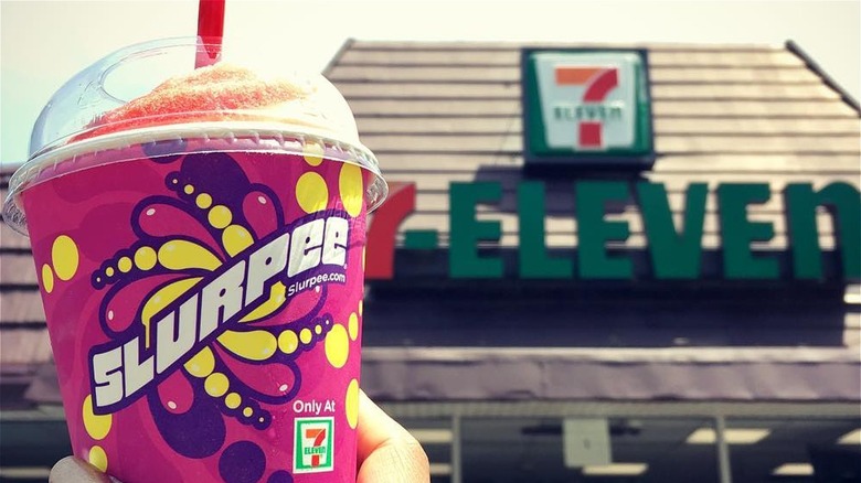 Person holding red 7-Eleven Slurpee