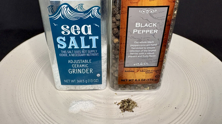 Salt and pepper with grinders on a plate