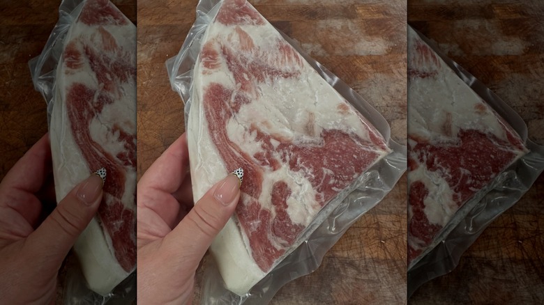 Woman holding a vacuum-sealed slab of salt pork