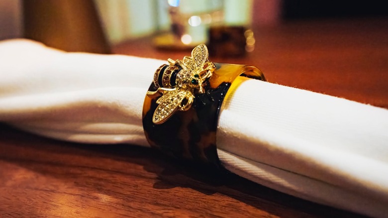 Napkin rings with a jeweled bee decoration at l'abeille restaurant