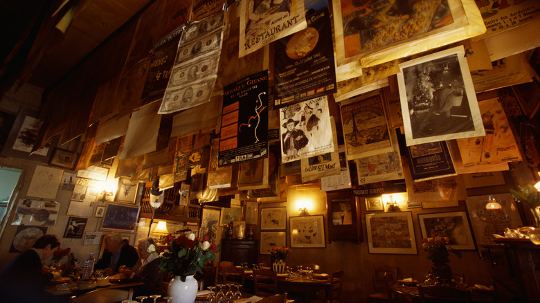 A restaurant interior with lots of artwork hanging on the wall