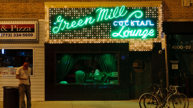 The bright green neon sign of the Green Mill Lounge at night