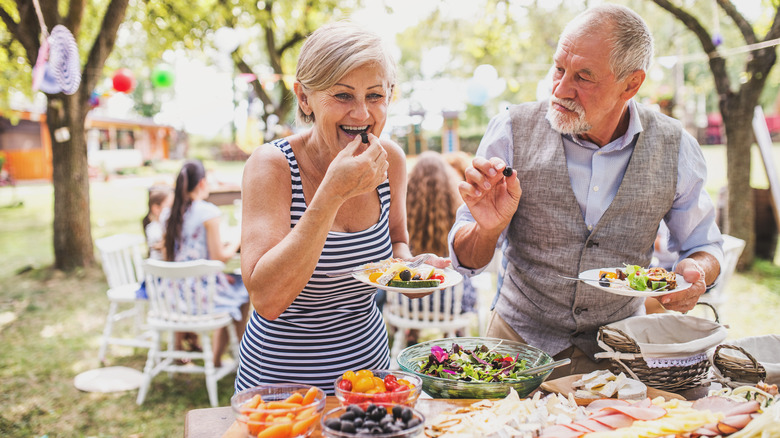 man and woman at garden party with buffet