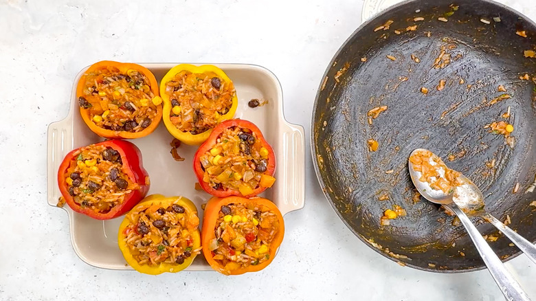 bell peppers stuffed with rice, beans and corn in baking dish